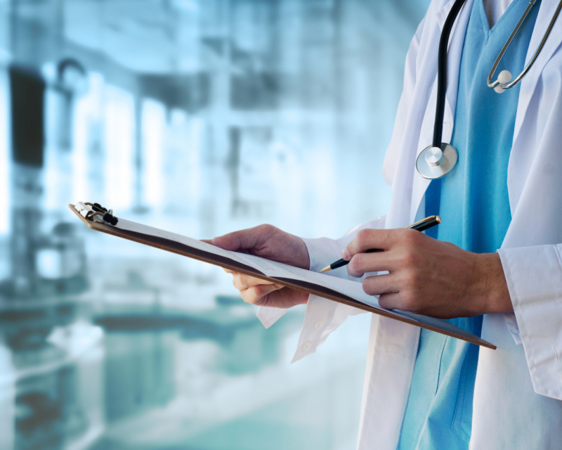 Doctor writing notes on a clipboard