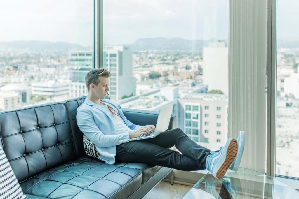 Digital content creation for engagement Man working on a laptop in a modern office with a city view, symbolizing digital content creation.