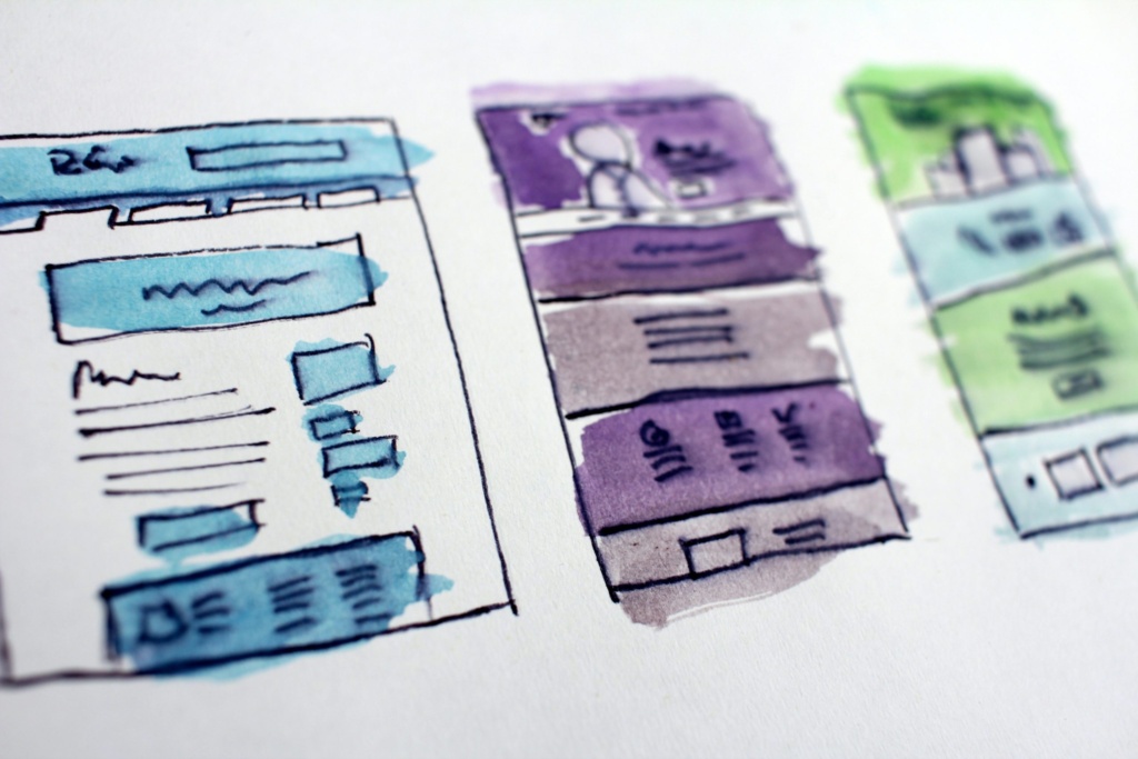 Custom website wireframe sketch image Hand-drawn sketches of website wireframes with watercolor highlights in blue, purple, and green.