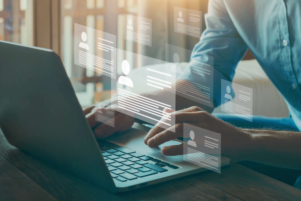 Digital HR recruitment and employee data management technology Person using a laptop with digital profile icons and data overlays representing online recruitment and employee management.