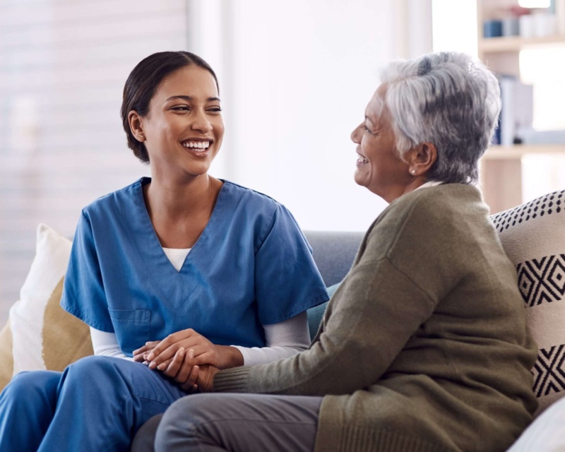 A nurse and a patient talking on a couch