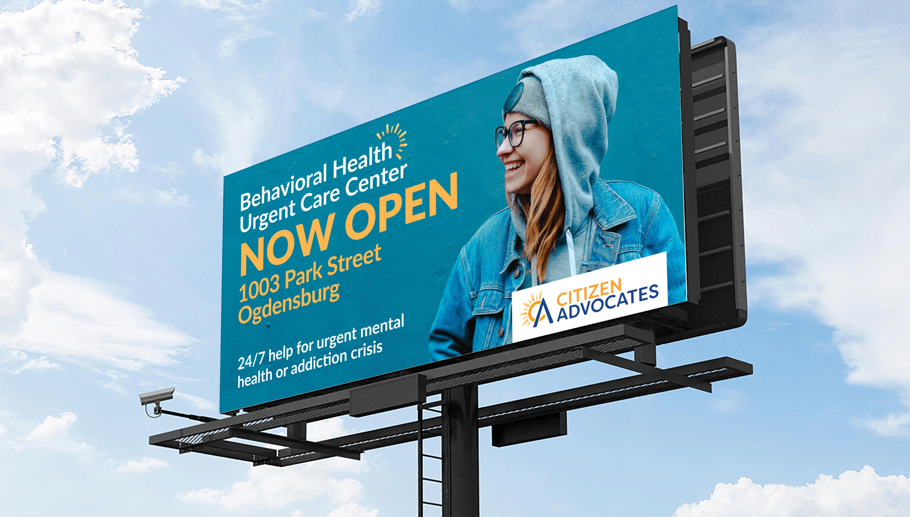 Billboard with a young woman on it and text promoting the opening of the behavioral health urgent care center