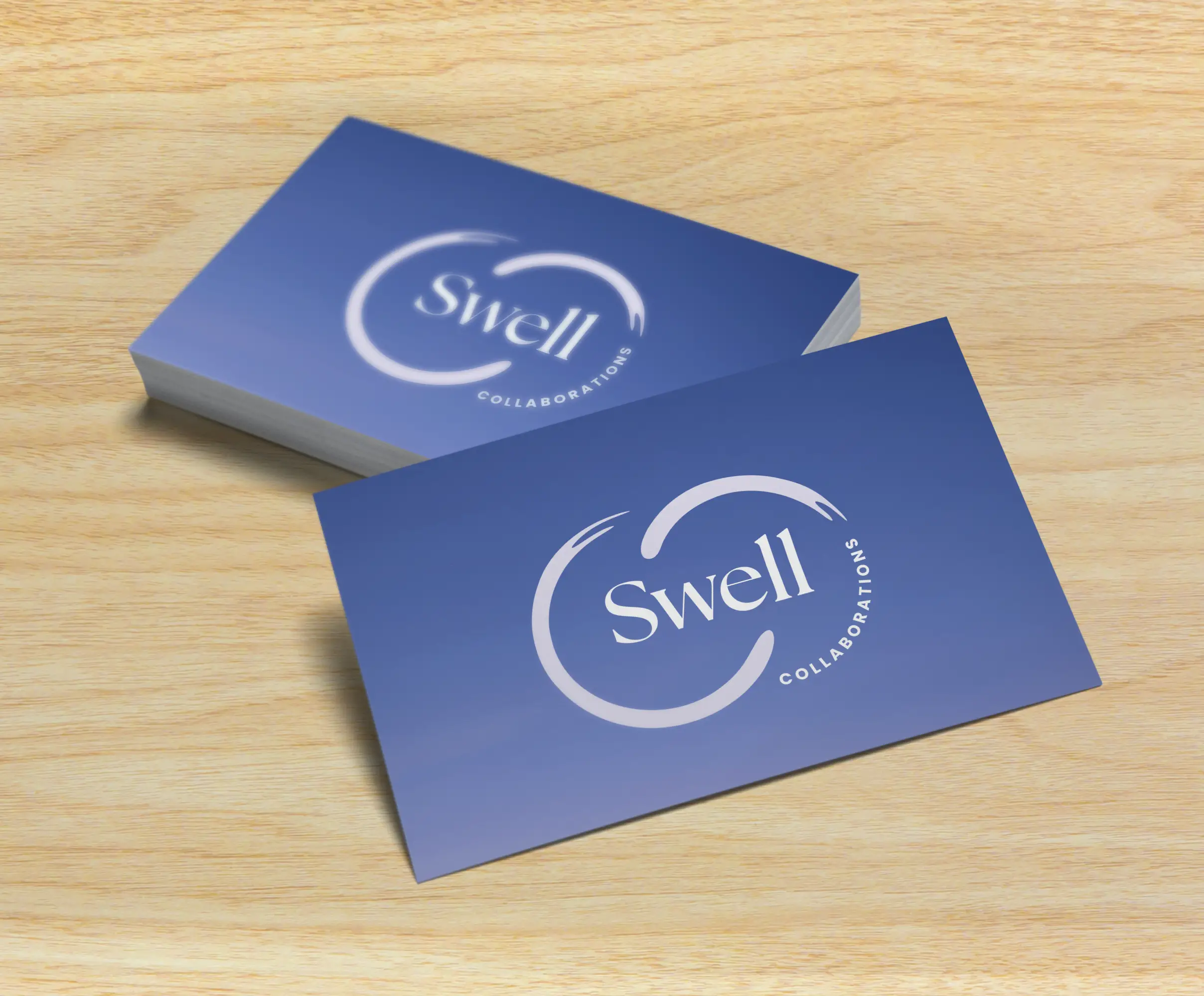 Stack of business cards featuring the Swell logo and brand gradient, designed to convey calm, professionalism, and intentional growth.